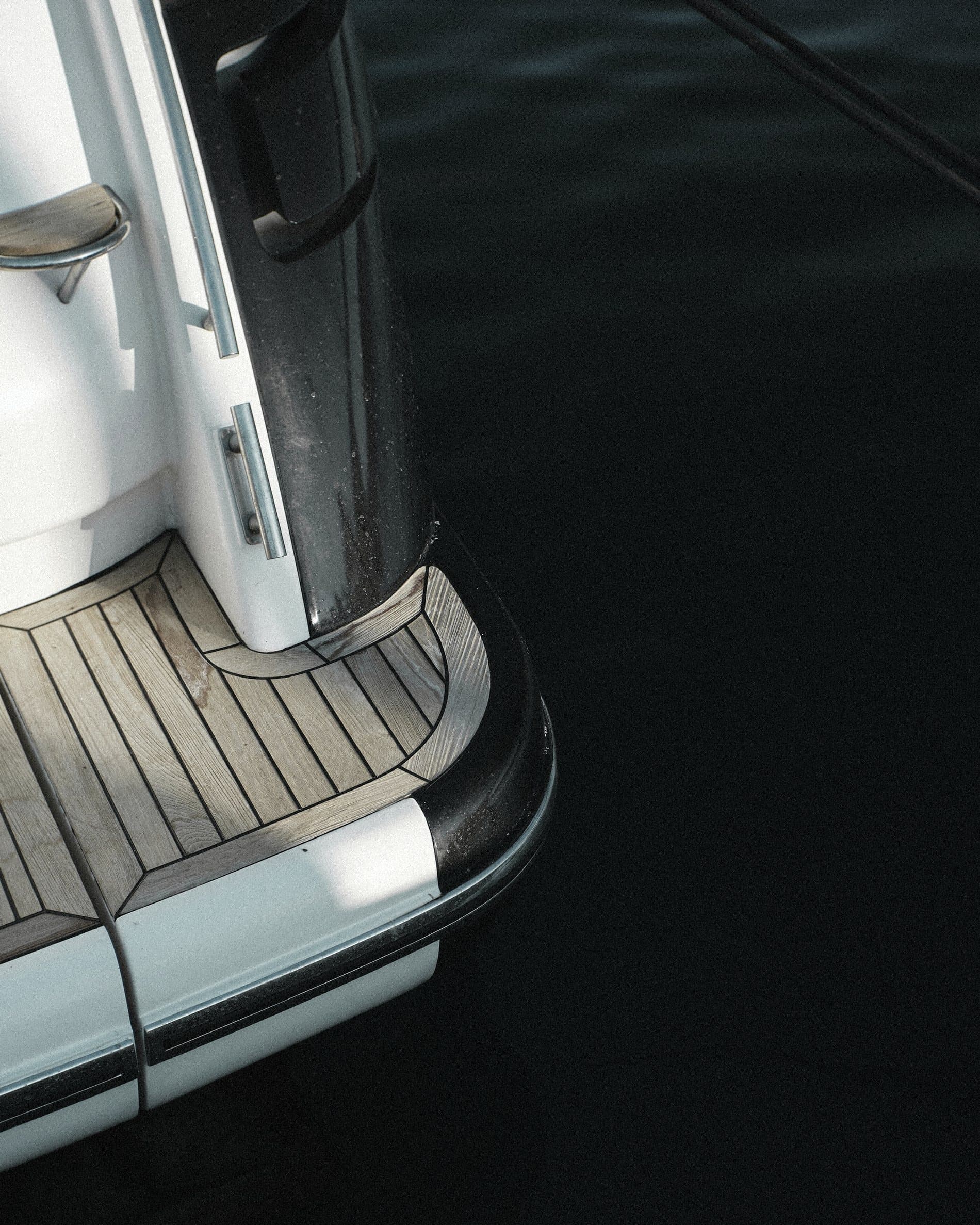 The transom and bathing platform of a yacht on dark water